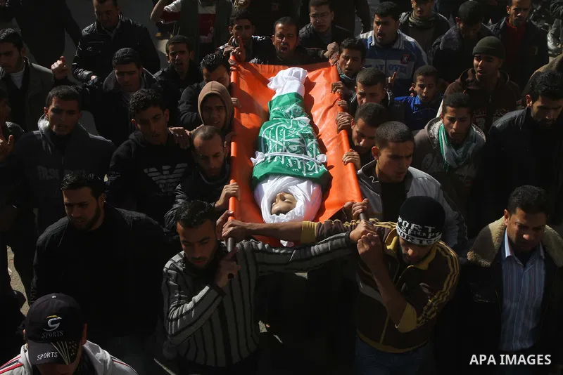 Palestinians carry the body of Ramadan Al Zalan, 12, at his family house during his funeral in Al Shatea refugee camp in the west of Gaza City on, 10 December 2011. Ramadan was injured yesterday and his father Bahjat Al...
