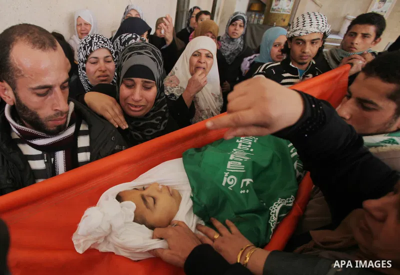 Palestinians carry the body of Ramadan Al Zalan, 12, at his family house during his funeral in Al Shatea refugee camp in the west of Gaza City on, 10 December 2011. Ramadan was injured yesterday and his father Bahjat Al...