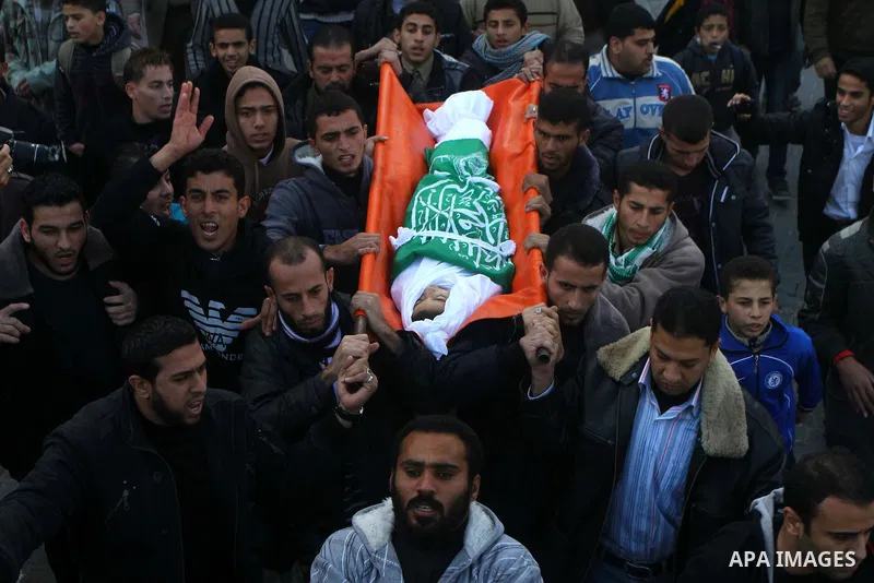 Palestinians carry the body of Ramadan Al Zalan, 12, at his family house during his funeral in Al Shatea refugee camp in the west of Gaza City on, 10 December 2011. Ramadan was injured yesterday and his father Bahjat Al...