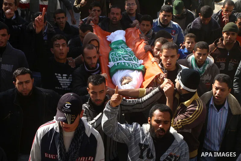Palestinians carry the body of Ramadan Al Zalan, 12, at his family house during his funeral in Al Shatea refugee camp in the west of Gaza City on, 10 December 2011. Ramadan was injured yesterday and his father Bahjat Al...