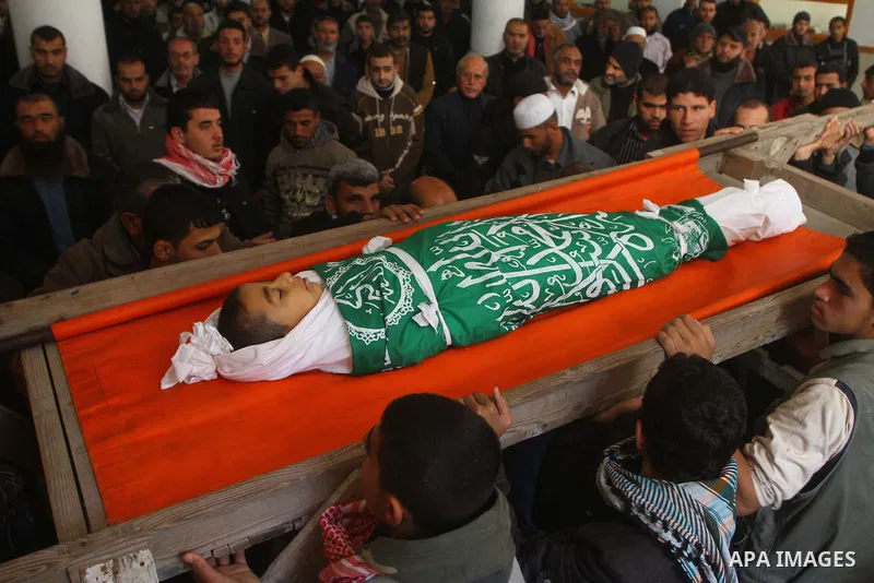 Palestinians carry the body of Ramadan Al Zalan, 12, at his family house during his funeral in Al Shatea refugee camp in the west of Gaza City on, 10 December 2011. Ramadan was injured yesterday and his father Bahjat Al...