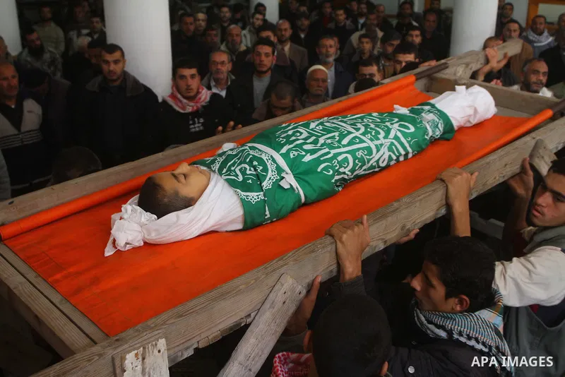 Palestinians carry the body of Ramadan Al Zalan, 12, at his family house during his funeral in Al Shatea refugee camp in the west of Gaza City on, 10 December 2011. Ramadan was injured yesterday and his father Bahjat Al...