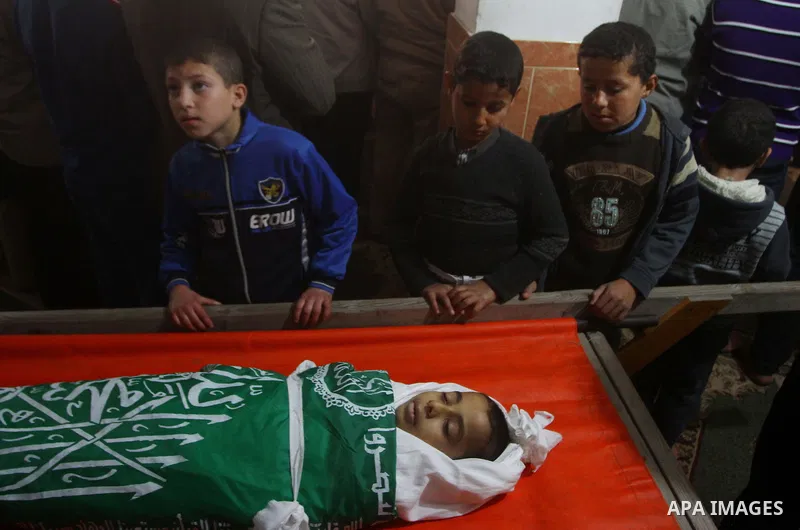 Palestinians carry the body of Ramadan Al Zalan, 12, at his family house during his funeral in Al Shatea refugee camp in the west of Gaza City on, 10 December 2011. Ramadan was injured yesterday and his father Bahjat Al...