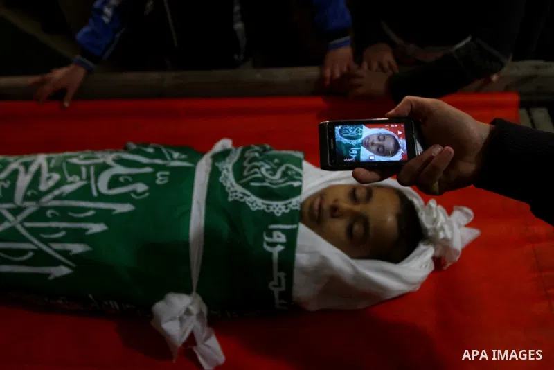 Palestinians carry the body of Ramadan Al Zalan, 12, at his family house during his funeral in Al Shatea refugee camp in the west of Gaza City on, 10 December 2011. Ramadan was injured yesterday and his father Bahjat Al...