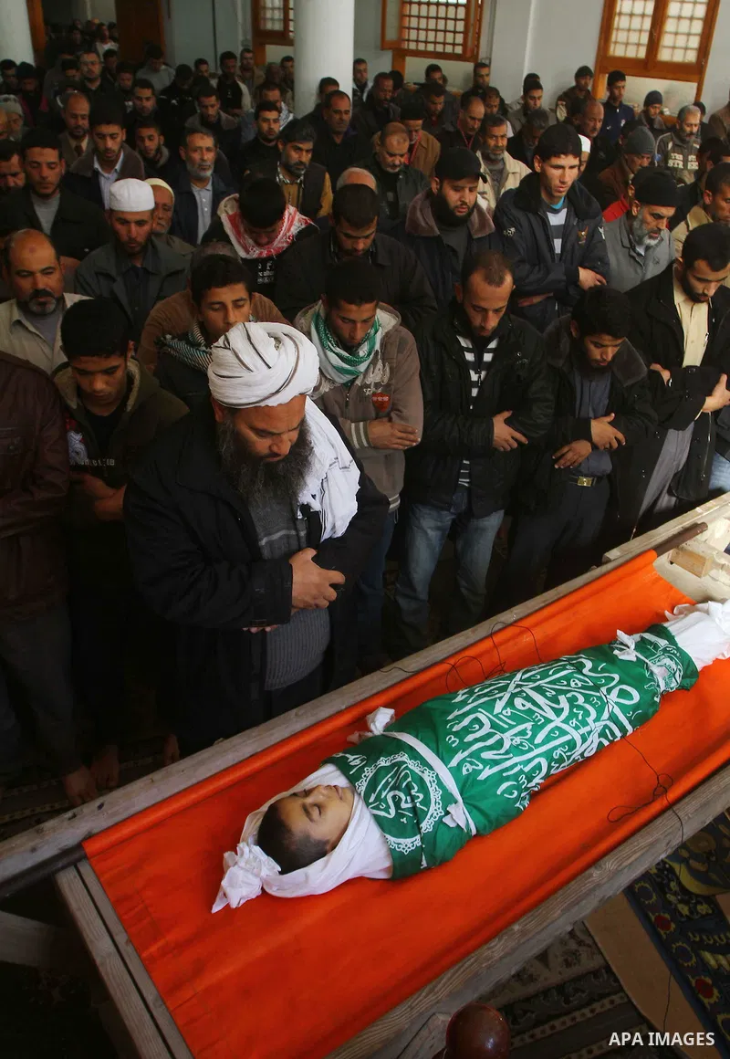 Palestinian mourners perform the prayers on the body of Ramadan al-Zaalan,12, during his funeral in Al Shatea refugee camp in the west of Gaza City on, 10 December 2011. Ramadan was injured yesterday and his father Bahja...