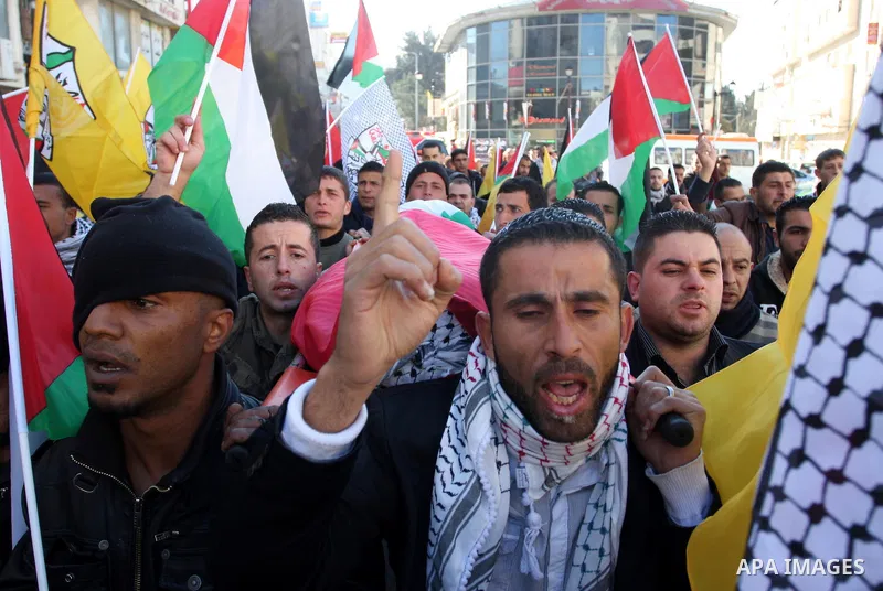 Palestinians carry the body of Mustafa Tamimi during his funeral in the West Bank city of Ramallah, Sunday, Dec. 11, 2011. Tamini, 28, was hurling rocks at an Israeli military vehicle on Friday in the West Bank village o...