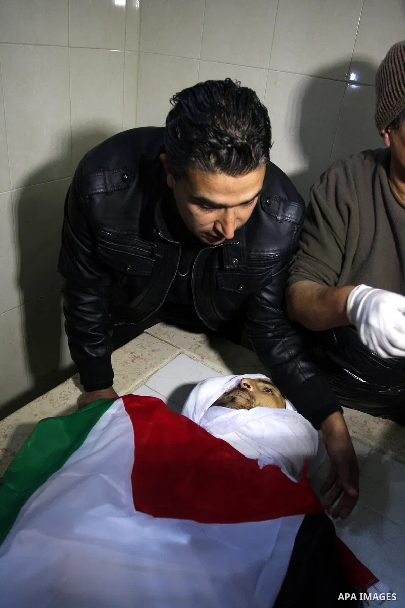 Palestinians prepare the body of Mustafa Tamimi prior to his funeral at a hospital in the West Bank city of Ramallah, Sunday, Dec. 11, 2011. Tamini, 28, was hurling rocks at an Israeli military vehicle on Friday in the W...