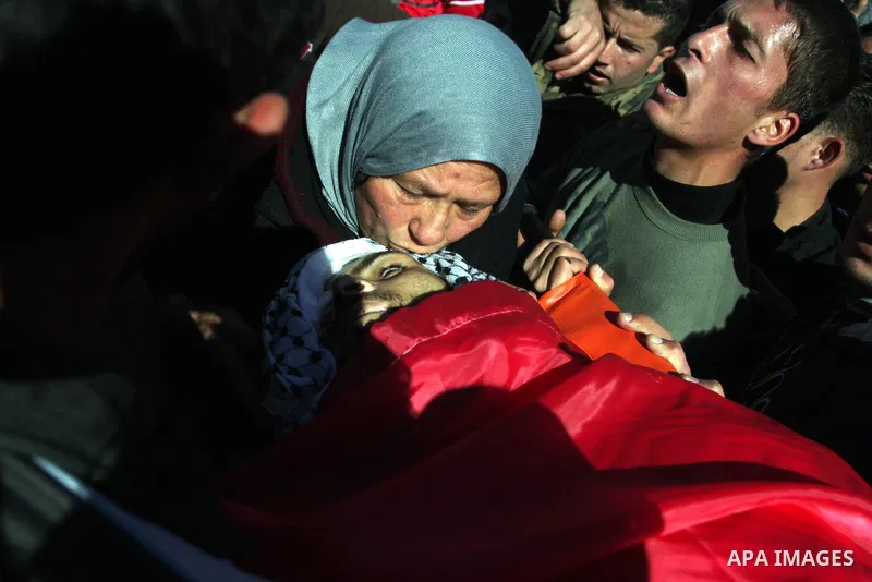 Relatives mourn during the funeral of Palestinian activist Mustafa al-Tamimi in the West Bank village of Nabi Saleh on December 11, 2011. Tamimi, 28, was hurling rocks at an Israeli military vehicle on Friday in the West...