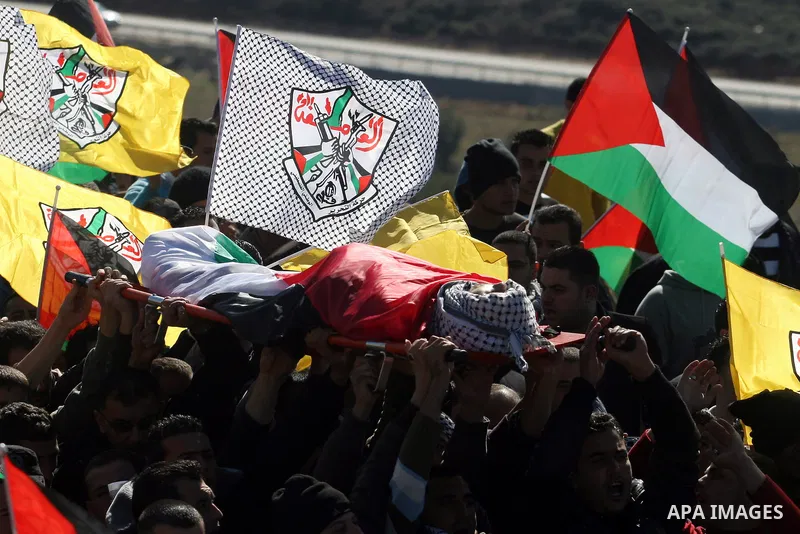 Palestinians carry the body of Mustafa Tamimi during his funeral in the West Bank city of Ramallah, Sunday, Dec. 11, 2011. Tamini, 28, was hurling rocks at an Israeli military vehicle on Friday in the West Bank village o...