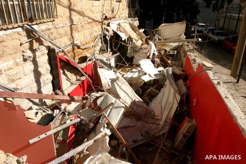 A Palestinians inspect the rubble of their house follow an Israeli bulldozer demolished it that was built without a construction permit, in the Arab Jerusalem city on Dec. 12, 2011. Photo by Mahfouz Abu Turk