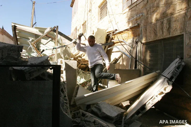 A Palestinians inspect the rubble of their house follow an Israeli bulldozer demolished it that was built without a construction permit, in the Arab Jerusalem city on Dec. 12, 2011. Photo by Mahfouz Abu Turk