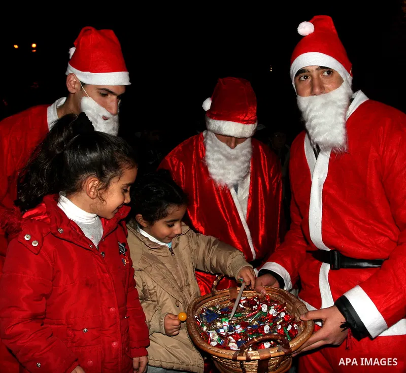 Palestinians light candles during a ceremony for lighting the Christmas tree, in the West Bank City of Ramallah, On Dec.13, 2011. Photo by Issam Rimawi