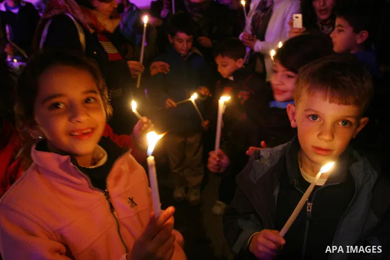 Palestinians light candles during a ceremony for lighting the Christmas tree, in the West Bank City of Ramallah, On Dec.13, 2011. Photo by Issam Rimawi