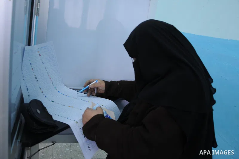 A woman reads a ballot paper before casting his vote at polling station in Giza, southwest of Cairo, on December 14, 2011, during the second stage of Egypt's parliamentary elections. Some 18.8 million Egyptians are eligi...