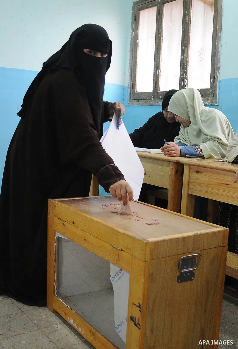 An Egyptian woman votes at a polling station in Giza, southwest of Cairo, on December 14, 2011, during the second stage of Egypt's parliamentary elections. Some 18.8 million Egyptians are eligible to cast their ballots i...
