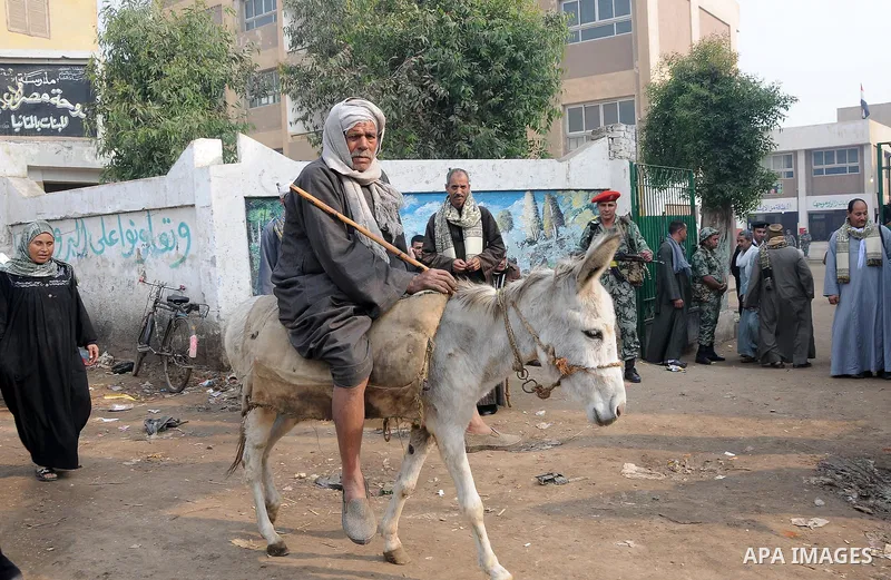 Egyptians wait to vote outside a polling station in Giza, southwest of Cairo, on December 14, 2011, during the second stage of Egypt's parliamentary elections. Some 18.8 million Egyptians are eligible to cast their ballo...
