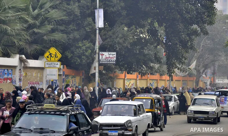 Egyptian woman wait to vote outside a polling station in Giza, southwest of Cairo, on December 14, 2011, during the second stage of Egypt's parliamentary elections. Some 18.8 million Egyptians are eligible to cast their...
