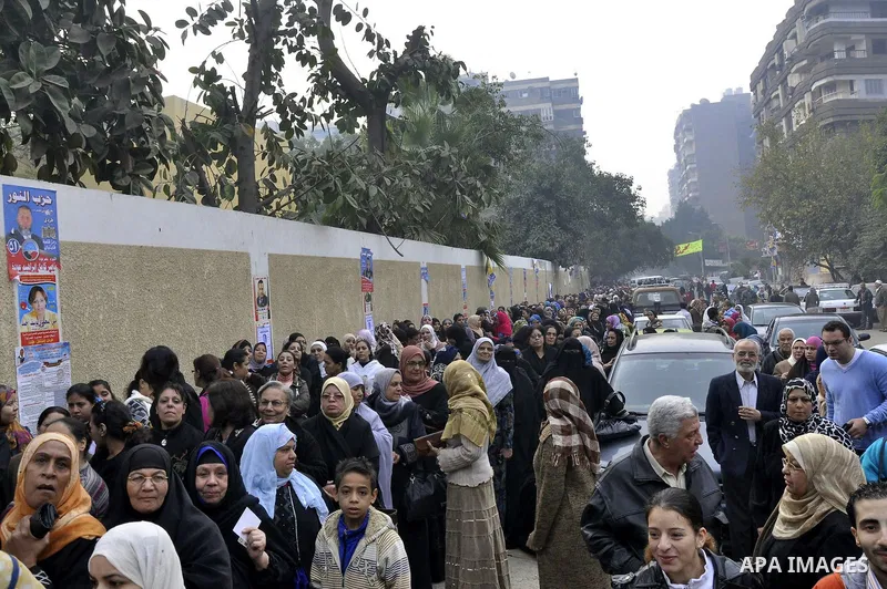 Egyptian women wait to vote outside a polling station in Giza, southwest of Cairo, on December 14, 2011, during the second stage of Egypt's parliamentary elections. Some 18.8 million Egyptians are eligible to cast their...