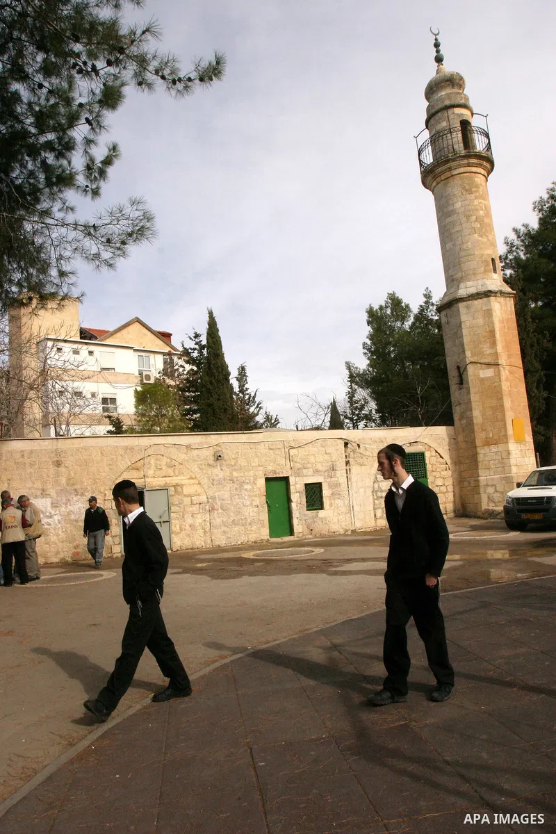 Ultra orthodox Jewish walk out of a vandalised mosque in Jerusalem December 14, 2011. The unused mosque in Jerusalem was set ablaze and graffiti sprayed on its walls on Wednesday in a manner similar to recent attacks ass...