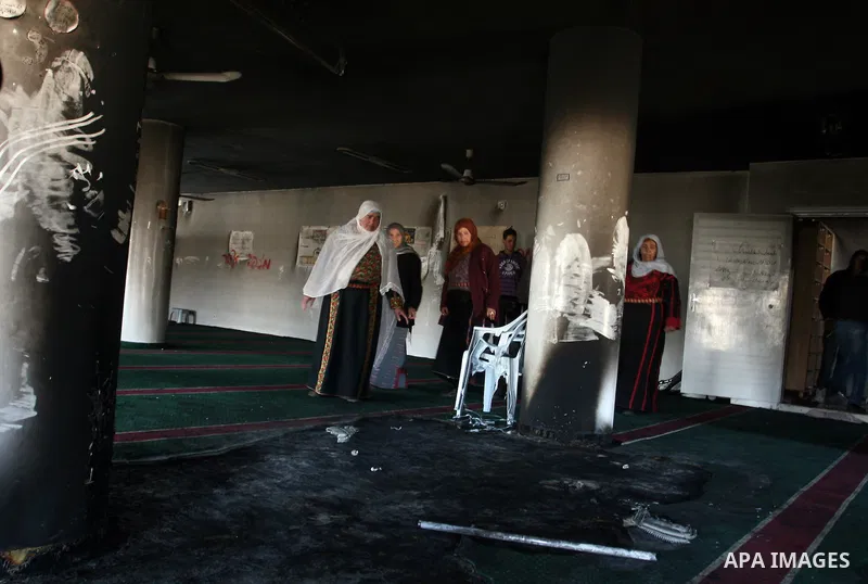 Palestinian women from the West bank village of Burqa near Ramallah, view the damage at the village Al-Nur mosque, on 15 December 2011. The mosque was set on fire during the night allegedly by Israeli settlers and Hebrew...
