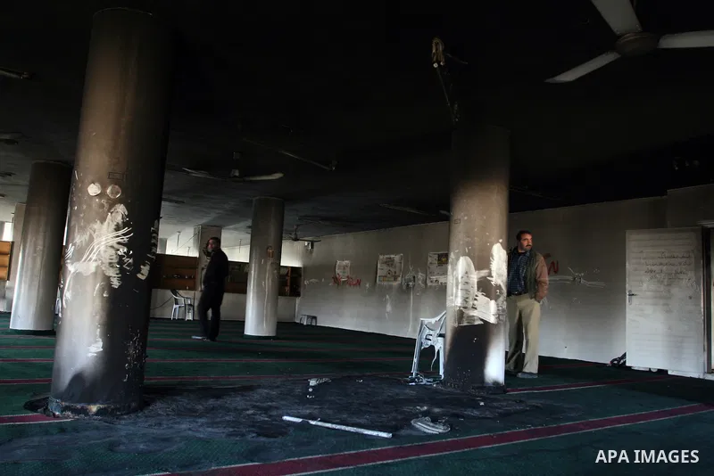 Palestinians from the West bank village of Burqa near Ramallah, view the damage at the village Al-Nur mosque, on 15 December 2011. The mosque was set on fire during the night allegedly by Israeli settlers and Hebrew slog...
