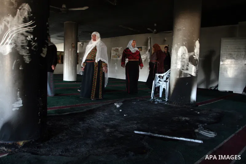 Palestinian women from the West bank village of Burqa near Ramallah, view the damage at the village Al-Nur mosque, on 15 December 2011. The mosque was set on fire during the night allegedly by Israeli settlers and Hebrew...