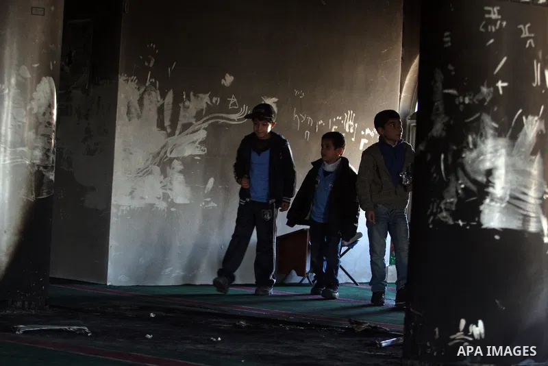 Palestinians from the West bank village of Burqa near Ramallah, view the damage at the village Al-Nur mosque, on 15 December 2011. The mosque was set on fire during the night allegedly by Israeli settlers and Hebrew slog...