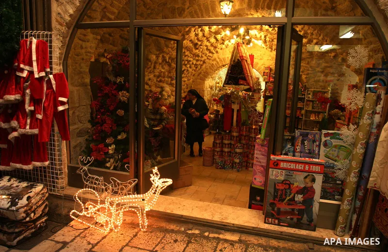 A Palestinian vendor displays gifts for Christmas at his shop in the main market in Jerusalem's old city, 15 December 2011. Christian worshippers began their spiritual preparations ahead of Christmas Eve and tourists fro...