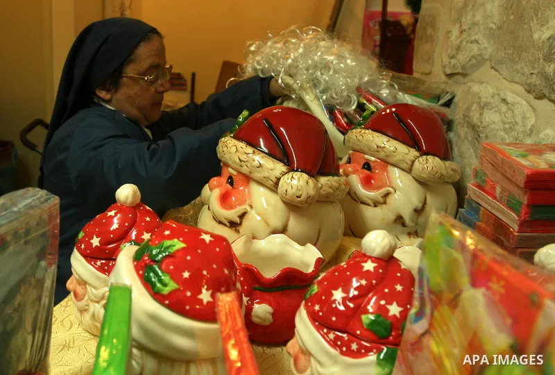 A Palestinian vendor displays gifts for Christmas at his shop in the main market in Jerusalem's old city, 15 December 2011. Christian worshippers began their spiritual preparations ahead of Christmas Eve and tourists fro...