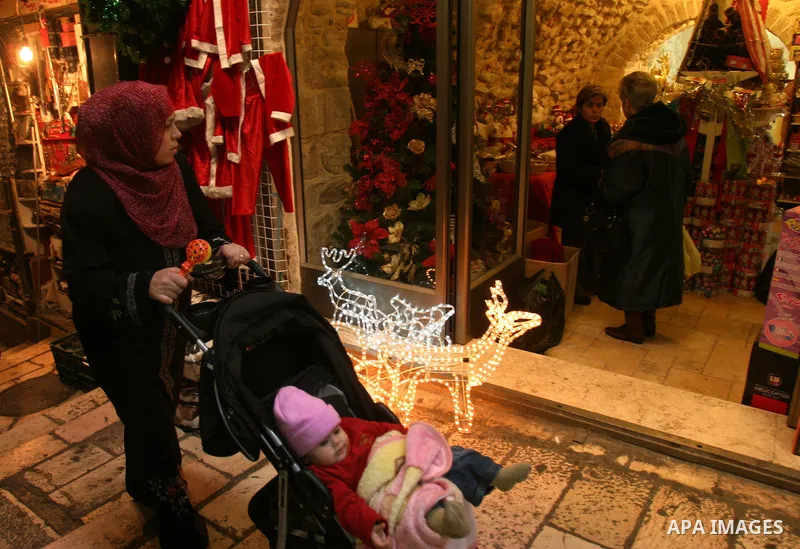 A Palestinian vendor displays gifts for Christmas at his shop in the main market in Jerusalem's old city, 15 December 2011. Christian worshippers began their spiritual preparations ahead of Christmas Eve and tourists fro...