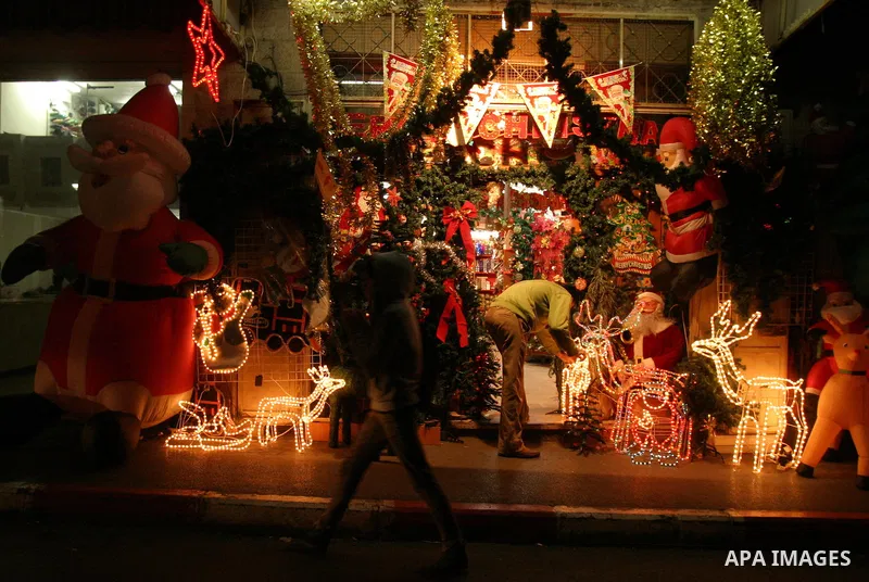 A Palestinian vendor displays gifts for Christmas at his shop in the main market in Jerusalem's old city, 15 December 2011. Christian worshippers began their spiritual preparations ahead of Christmas Eve and tourists fro...