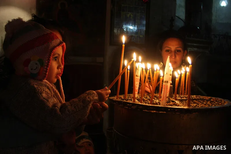 A Palestinian girl lights a candle in the Church of the Nativity, the site revered as the birthplace of Jesus, in the West Bank town of Bethlehem December 15, 2011, ahead of Christmas. Christian worshippers began their s...