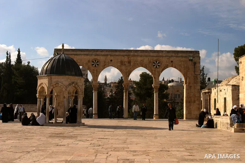 Palestinian Muslims walk in front of the Dome of the Rock after Friday prayers at Al-Aqsa mosque compound in Jerusalem's old city on Dec. 16,2011. Photo by Mahfouz Abu Turk