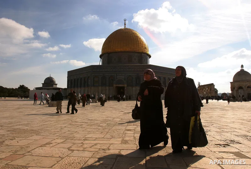 Palestinian Muslims walk in front of the Dome of the Rock after Friday prayers at Al-Aqsa mosque compound in Jerusalem's old city on Dec. 16,2011. Photo by Mahfouz Abu Turk