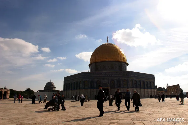 Palestinian Muslims walk in front of the Dome of the Rock after Friday prayers at Al-Aqsa mosque compound in Jerusalem's old city on Dec. 16,2011. Photo by Mahfouz Abu Turk