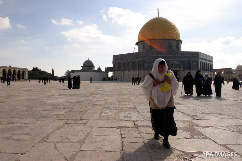 Palestinian Muslims walk in front of the Dome of the Rock after Friday prayers at Al-Aqsa mosque compound in Jerusalem's old city on Dec. 16,2011. Photo by Mahfouz Abu Turk