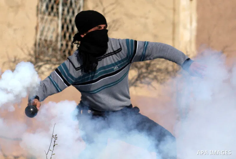 A Palestinian demonstrator hurls tear gas canister towards Israeli security forces during clashes at a weekly protest against a nearby Jewish settlement, in the West Bank village of Nabi Saleh, near Ramallah December 16,...