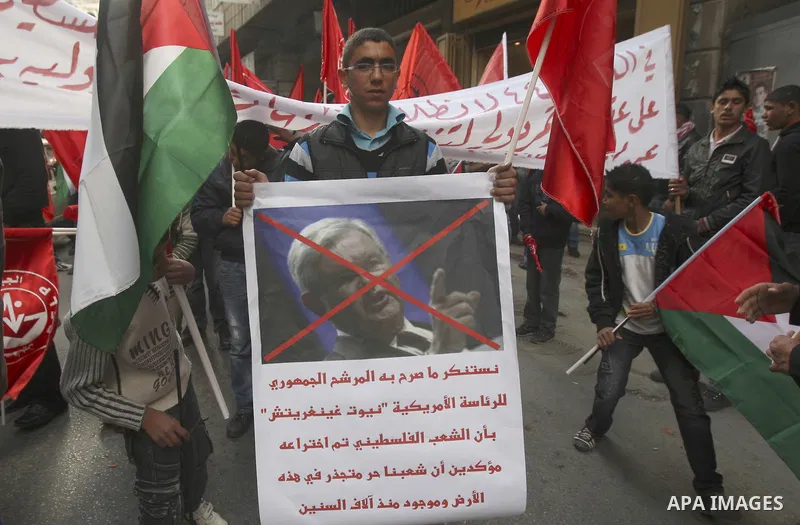 Palestinians hold a poster of U.S republican presidential candidate former House Speaker Newt Gingrich, during a rally marking the 44rd anniversary of the leftist Popular Front for the Liberation of Palestine (PFLP) in t...