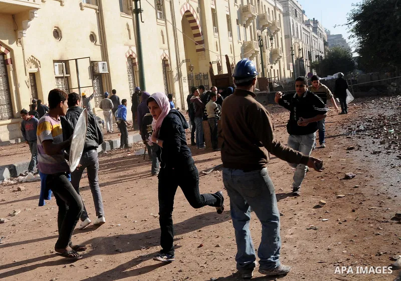 Egyptian protesters throw stones towards security forces during clashes in central Cairo on December 18, 2011 in the third straight day of violence which has left 10 people dead and some 500 wounded. Photo by Ahmed Asad