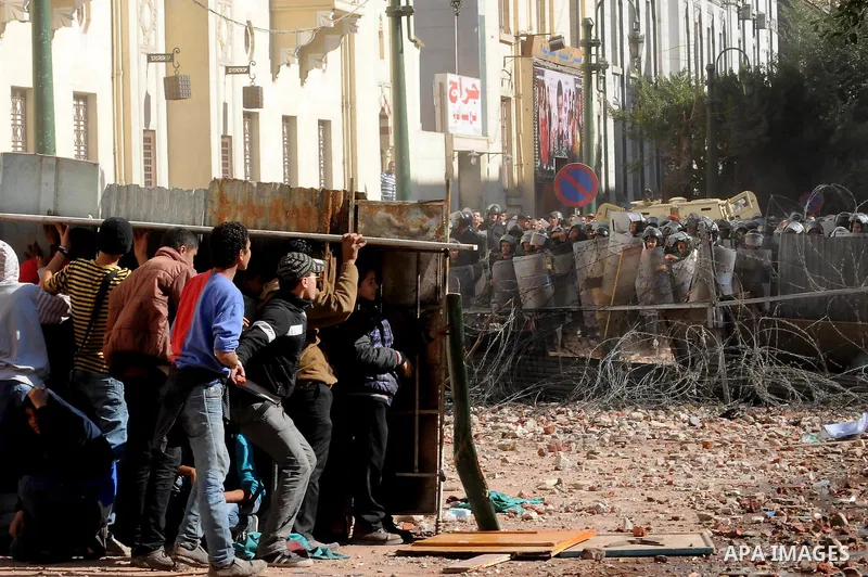 Egyptian protesters throw stones towards security forces during clashes in central Cairo on December 18, 2011 in the third straight day of violence which has left 10 people dead and some 500 wounded. Photo by Ahmed Asad