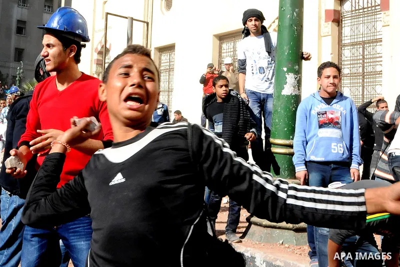 Egyptian protesters throw stones towards security forces during clashes in central Cairo on December 18, 2011 in the third straight day of violence which has left 10 people dead and some 500 wounded. Photo by Ahmed Asad