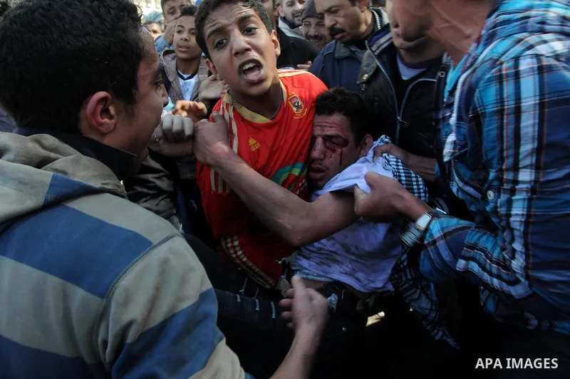 Egyptian medics help a young protester near Tahrir Square in Cairo, Egypt, Sunday, Dec. 18, 2011. Troops and protesters are clashing for the third straight day in Cairo, pelting each other with rocks in skirmishes near p...