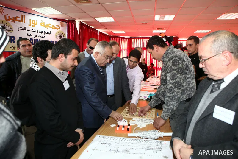 Palestinian Prime Minister Salam Fayyad visits the exhibition organized by Noor Al Ain "the light of eye" Association for the blind and visually impaired in the West Bank city of Ramallah on Dec. 18, 2011. Photo by Musta...