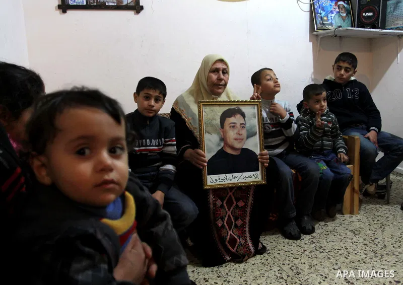 The mother of Palestinian prisoner Ali Abu Fool holds his picture before his release from an Israeli jail, in Gaza City December 18, 2011. Israel plans to release 550 Palestinian prisoners on Sunday in the second stage o...