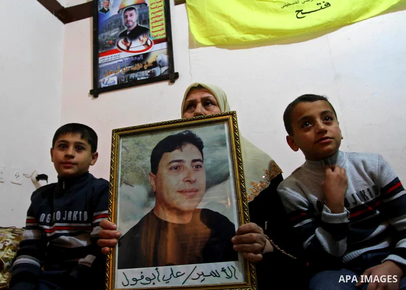 The mother of Palestinian prisoner Ali Abu Fool holds his picture before his release from an Israeli jail, in Gaza City December 18, 2011. Israel plans to release 550 Palestinian prisoners on Sunday in the second stage o...