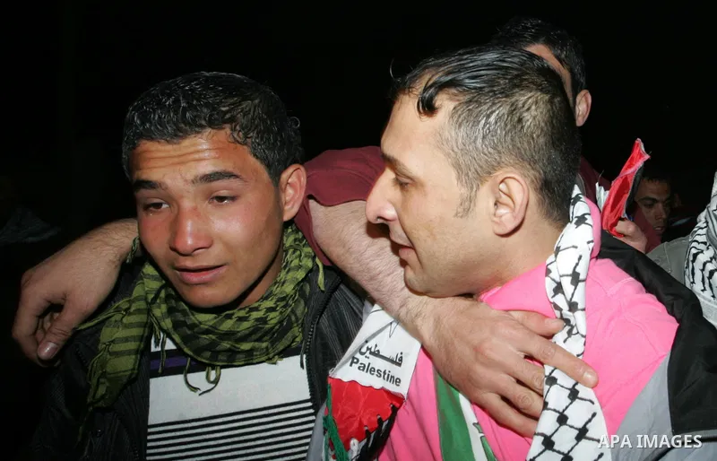A freed Palestinian prisoners is greeted upon arrival at Rafah crossing in the southern Gaza Strip December 18, 2011. Israel plans to release 550 Palestinian prisoners on Sunday in the second stage of a deal with Hamas t...