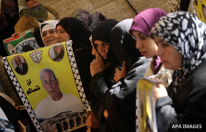 Palestinians women hold pictures of their prisoned relatives in Israeli jails as they gather in a weekly activity calling for their liberty at the Red Cross headquarters in Gaza City on Dec 19, 2011. About 7000 prisoners...