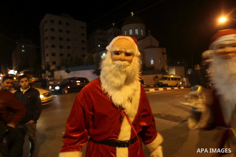 Palestinians watch the lighting of a Christmas tree outside the Church in West Bank town of Nablus Monday, Dec. 19, 2011. Christian worshipers began their spiritual preparations ahead of Christmas Eve and tourists from a...