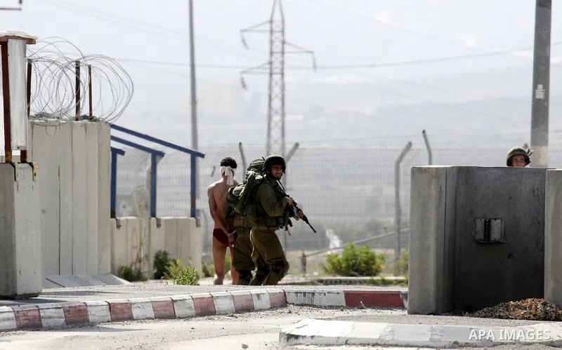 Israeli soldiers lead a stripped, blindfolded and handcuffed Palestinain youth to the back of the Huwara checkpoint after they suspected he was carrying explosives along with another boy near the West Bank city of Nablus...
