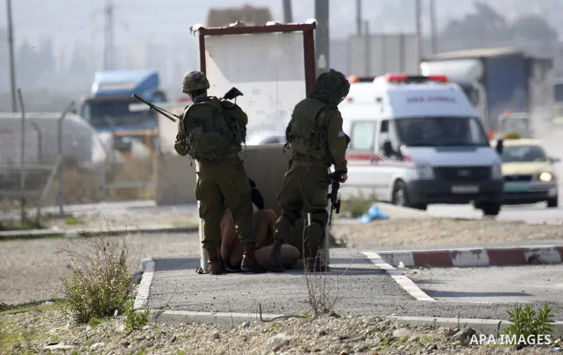 Israeli soldiers lead a stripped, blindfolded and handcuffed Palestinain youth to the back of the Huwara checkpoint after they suspected he was carrying explosives along with another boy near the West Bank city of Nablus...